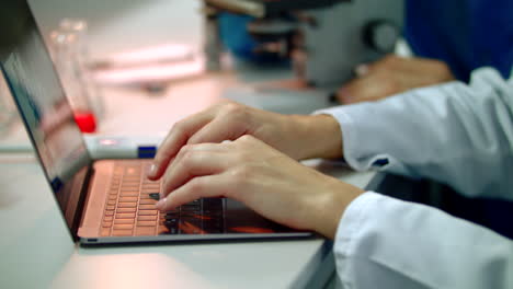 Scientist-hand-typing-on-laptop.-Close-up-of-female-scientist-hands-on-laptop